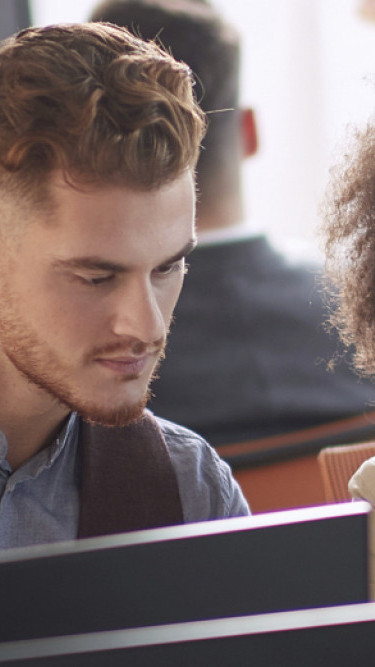 Two people discussing work at a computer